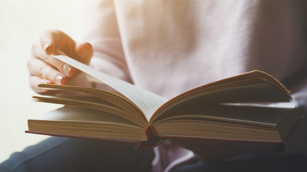 Main tournant la page d'un livre.